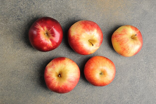 whole red ripe apples on a gray background