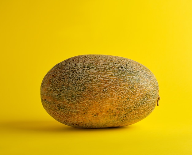 Whole ripe melon on a yellow , summer fruit