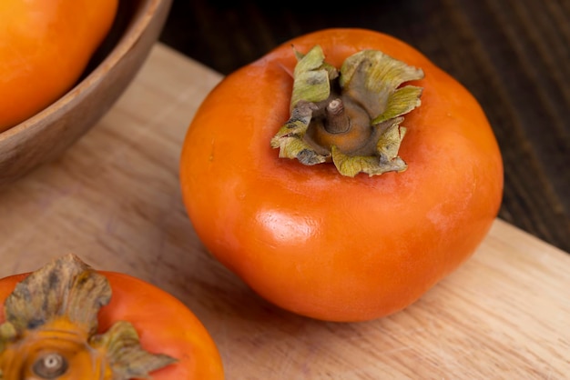 Whole ripe orange persimmon on the table unwashed orange persimmon fruits before cooking