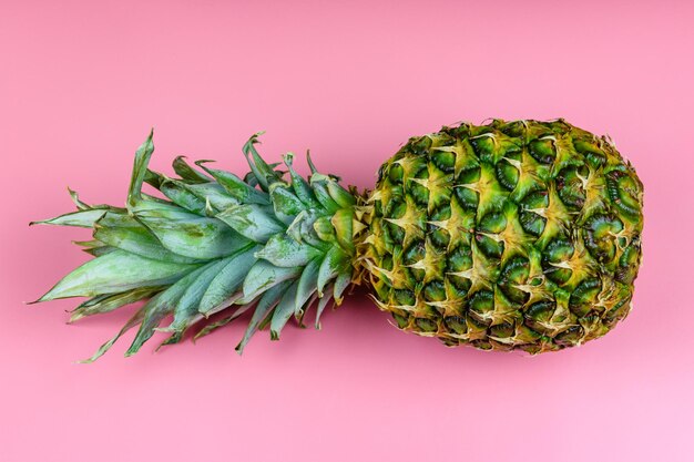 Whole ripe pineapple on the pink background