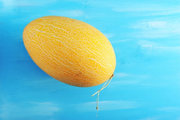 Photo whole ripe yellow melon on the wooden blue surface