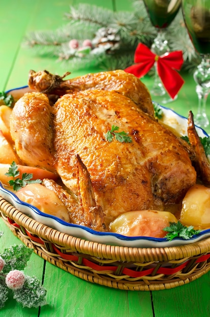 Photo whole roast chicken stuffed with apples, in a creamy sauce and slices of apples. christmas dinner