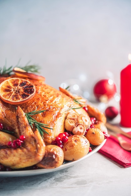 Whole roasted chicken with festive decoration candles light bokeh on concrete background copy