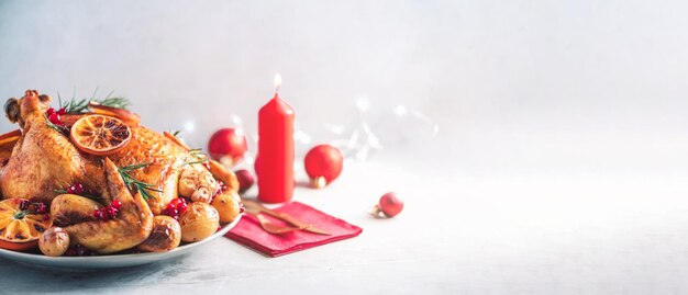 Whole roasted chicken with festive decoration candles light bokeh on concrete background