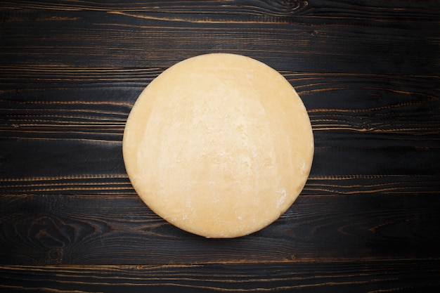 Whole round Head of parmesan or parmigiano hard cheese on wooden space