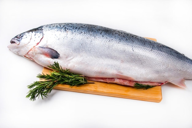 A whole salmon carcass on a chopping board. Red fish delicacy