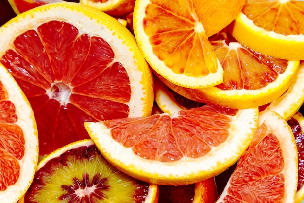 Whole and sliced juicy red oranges and grapefruits on a blue background Wallpaper food background