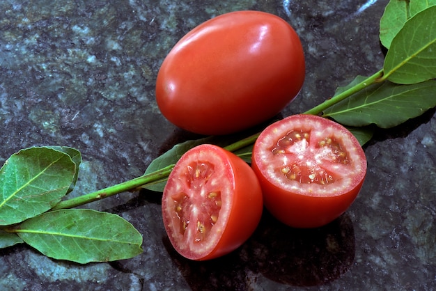 Whole and sliced tomatoes with bay leaves