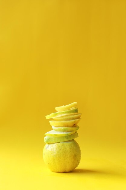 Whole and Slices of Lemon on Yellow Background Creative monochrome yellow mood