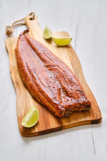 Whole smoked eel on wooden cutting board