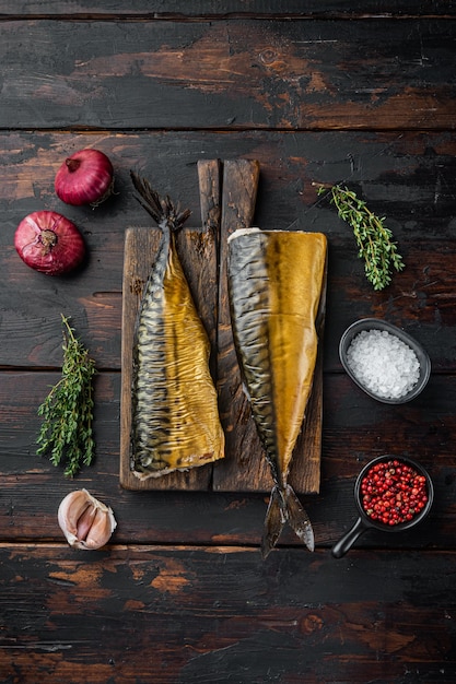 Whole smoked fish mackerel, on old dark  wooden table background, top view flat lay
