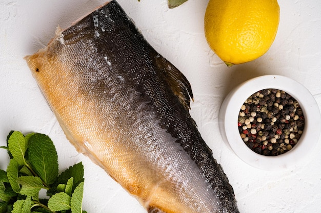 Whole smoked trout fish on white stone table background top view flat lay