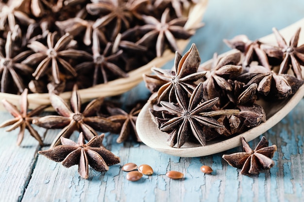 Whole star anise in a basket and spoon on wood