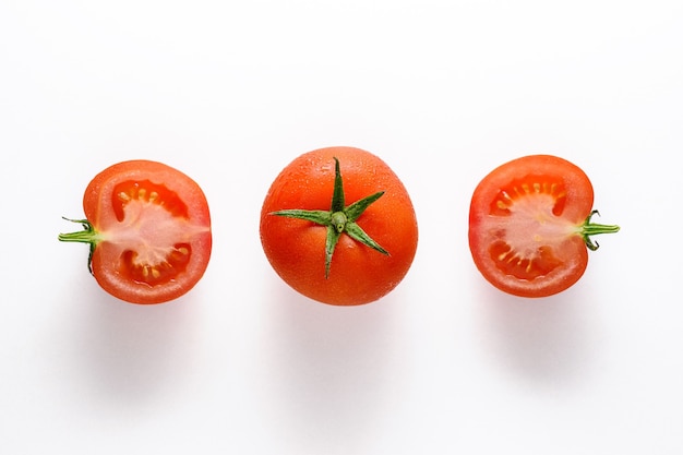 Pomodoro intero e mezzo pomodoro isolato su bianco.