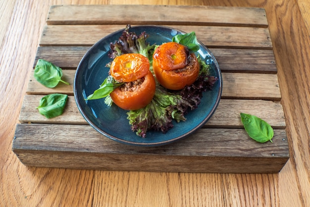 Whole tomato stuffed with ground beef chili on wooden table