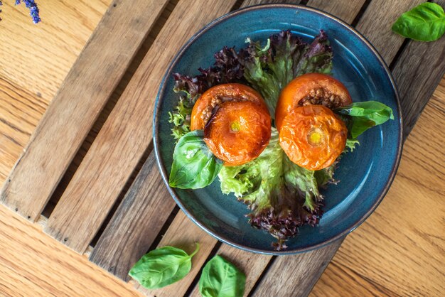 Whole tomato stuffed with ground beef chili on wooden table 