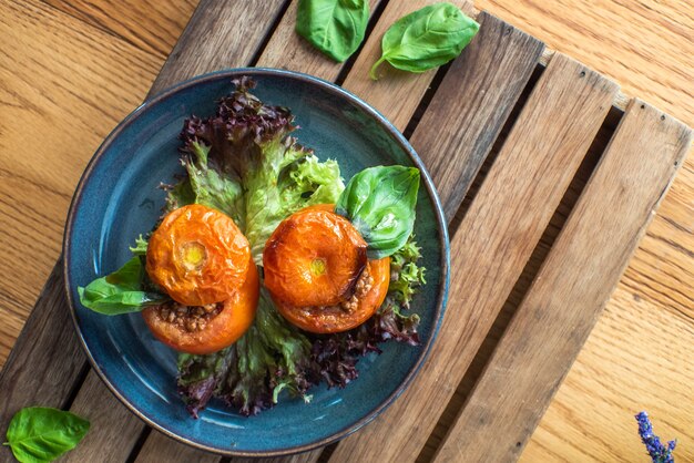 Whole tomato stuffed with ground beef chili on wooden table 