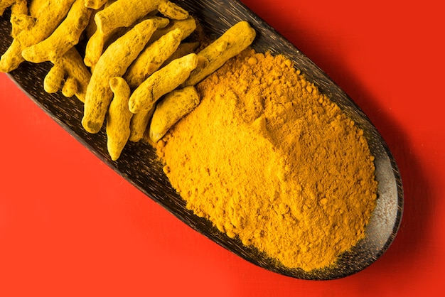 Photo whole turmeric and haldi or huldi powder heap