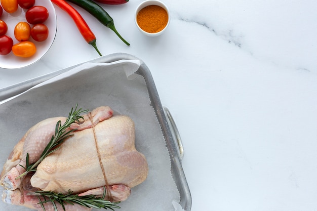 Whole uncooked chicken with herbs and spices