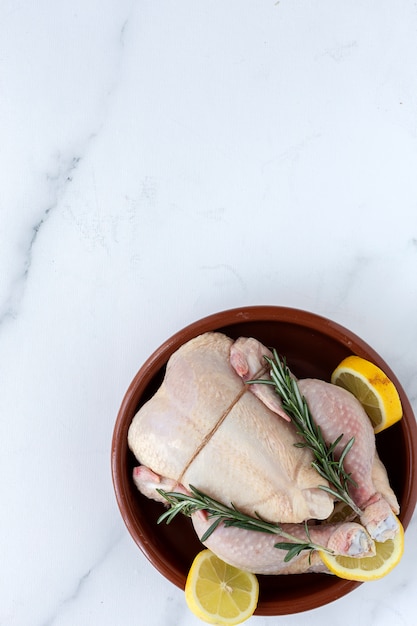 Whole uncooked chicken with herbs and spices