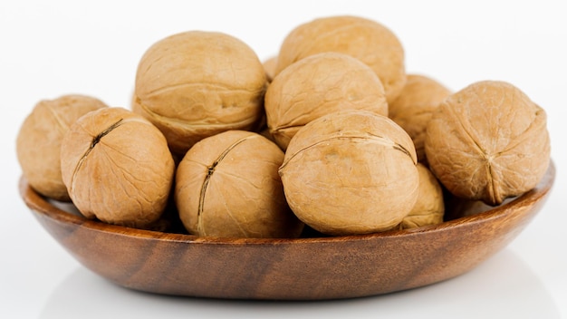 Whole walnut in a wooden bowl On white background