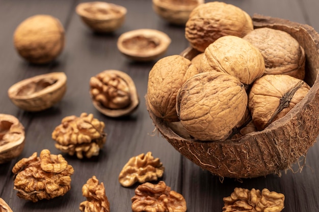 Whole walnuts in coconut shells Walnut kernels and shells on table