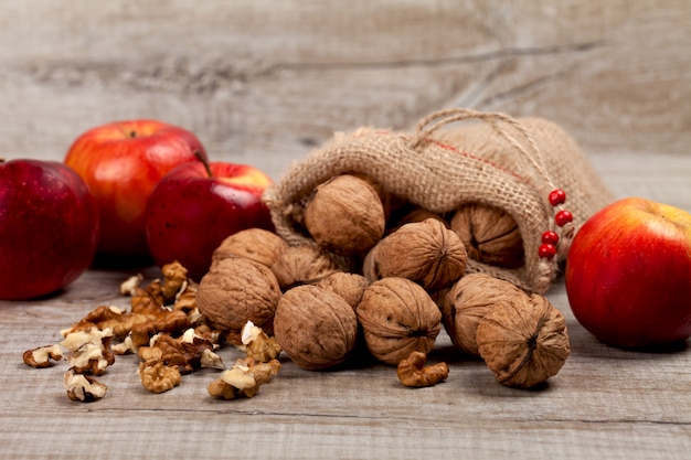 Whole walnuts, kernels and apples on the table