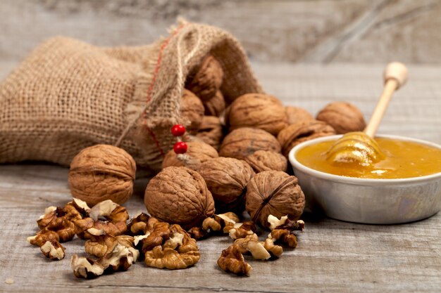 Whole walnuts, kernels and honey on the table