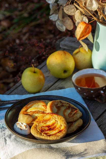 Whole wheat apple pancakes served with tea in the garden rustic style