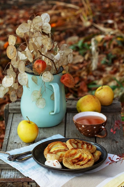 Whole wheat apple pancakes served with tea in the garden. Rustic style.