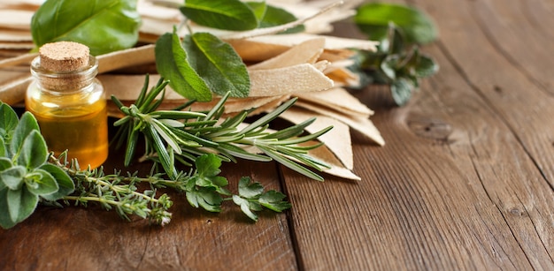 Whole wheat artisan pasta, olive oil and herbs on old wooden table close up with copy space