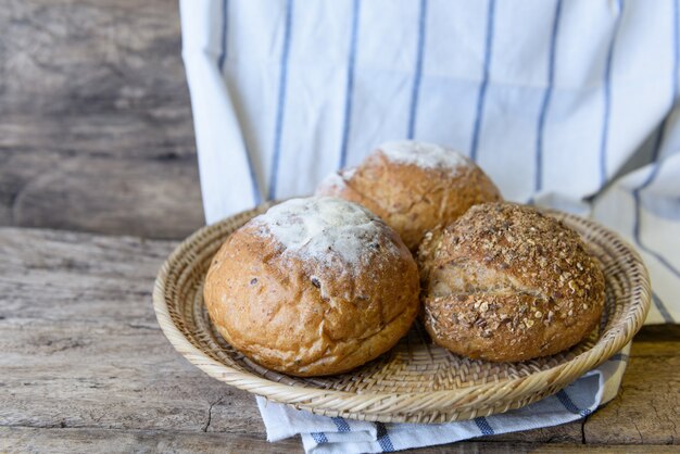 Whole wheat bread set in bamboo basket on wooden table top