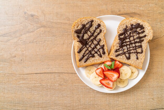 朝食に新鮮なバナナ、イチゴ、チョコレートで焼いた全粒粉パン