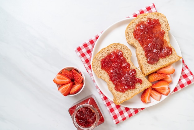 whole wheat bread with strawberry jam and fresh strawberry