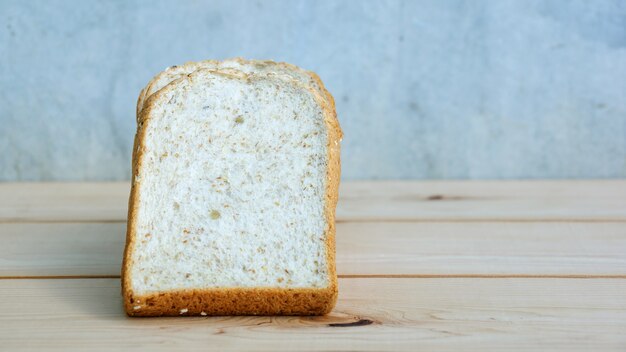 Whole wheat bread on wooden background.