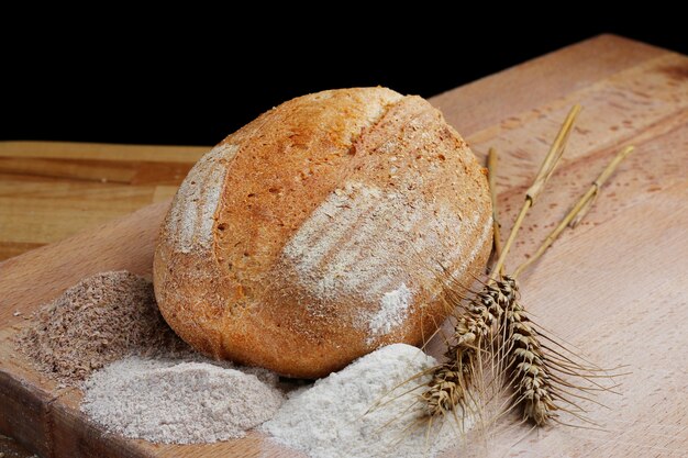 Whole wheat bread on wooden board. Freshly baked traditional bread on wooden table. Healthy food