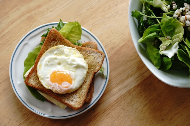 계란, 신선한 야채, 햄, 치즈, 행복하고 건강한 새 날을위한 건강 한 아침 식사와 통 밀 샌드위치.