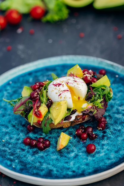 Whole wheat toasted bread with avocado poached egg soft cheese\
and mix salad healthy diet food breakfast