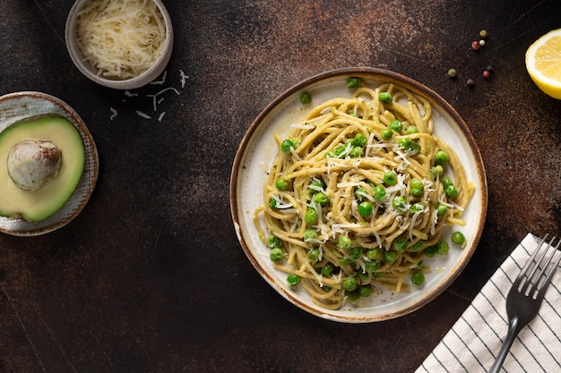 Whole wheat vegan pasta with green peas and avocado Italian food