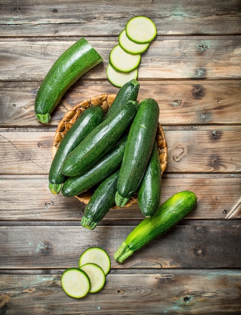 The whole zucchini the basket and slices of zucchini