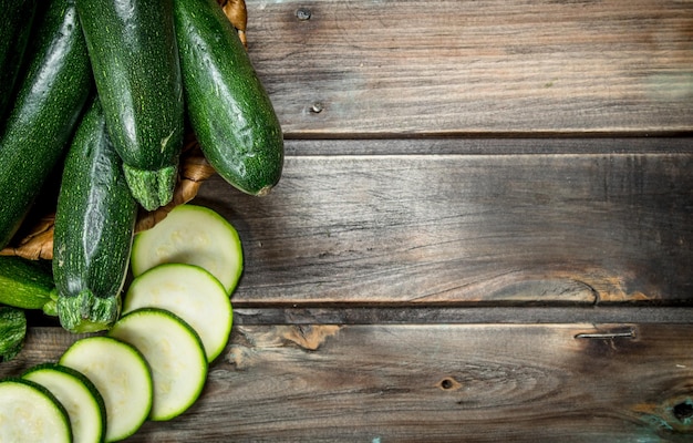 The whole zucchini the basket and slices of zucchini