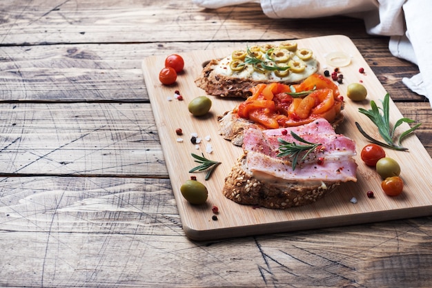 Wholegrain bread sandwiches with cream cheese, bacon and olives