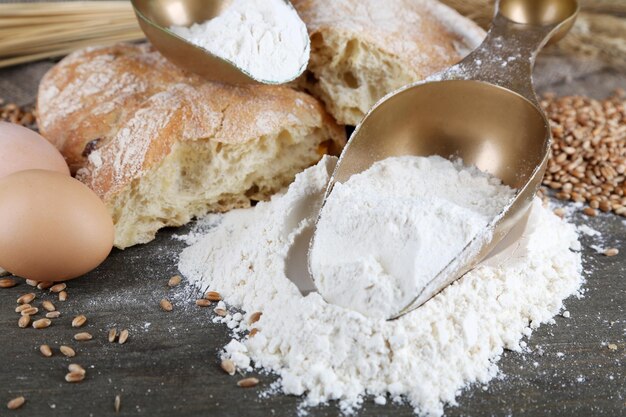 The wholemeal flour in scoops on wooden table