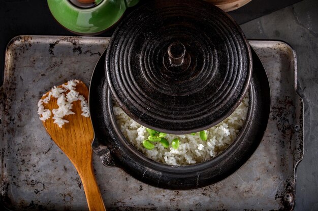Wholesome Fusion Top CloseUp of Edamame Served on Steamed White Rice in a Cast Iron Pot in 4k