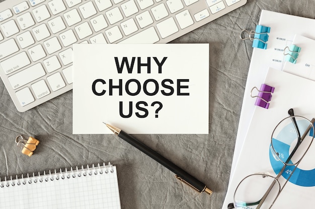 Why Choose Us is written in a document on the office desk with office accessories