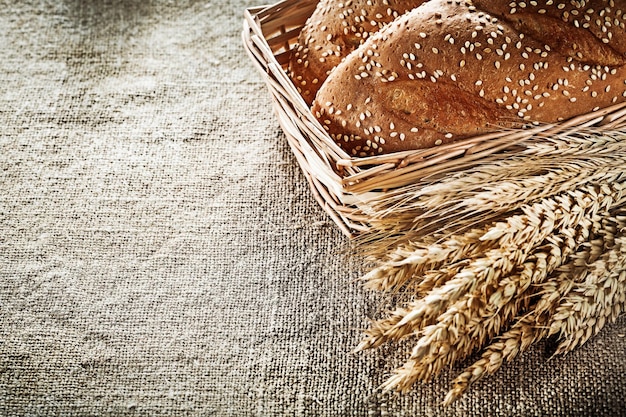 Wicker basket breadstick wheat ears on sacking background