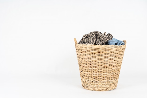 Wicker basket of clothes isolated on white  