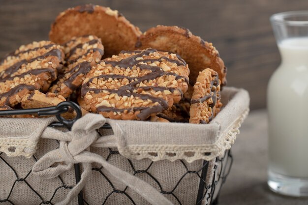 Wicker basket of of multigrain biscuits with glass of fresh milk.