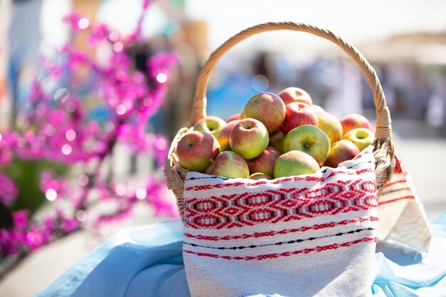 Плетеная корзина с яблоками на размытом фоне