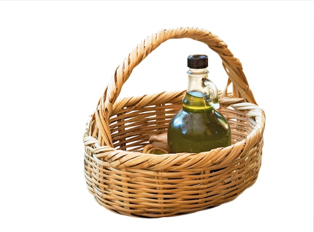 Wicker basket with a bottle of olive oil isolated on white background